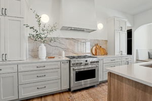 Gas range with generous cabinet space and granite backsplash