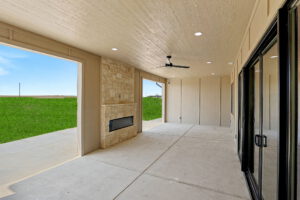 Back patio with sliding glass doors facing outdoor fireplace