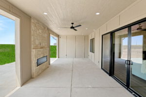 Back patio with sliding glass doors facing outdoor fireplace