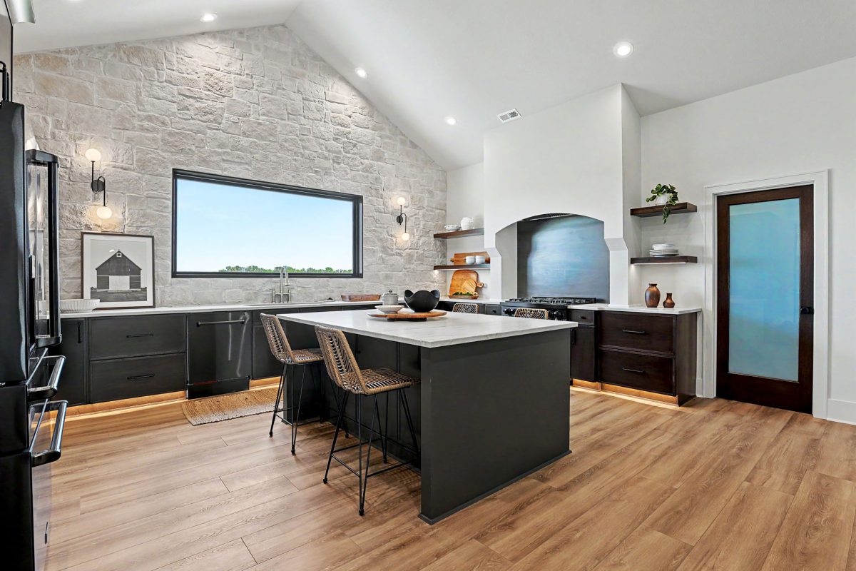 Kitchen with gas stove, island, and stone wall at 24411 W Stonebottom.