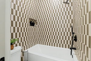 Guest bathroom with bath and shower with full tile backsplash